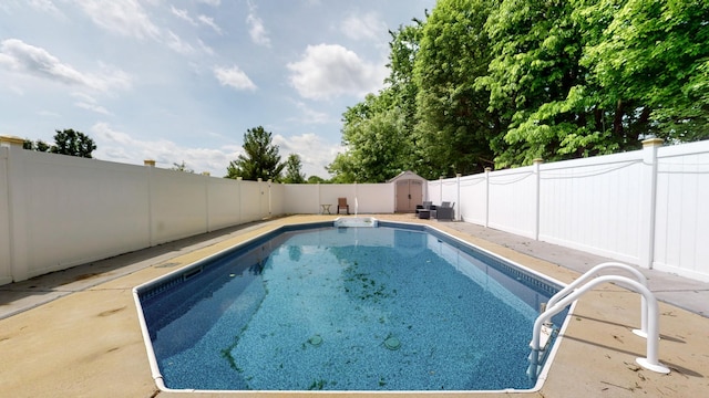 view of pool with a fenced backyard, an outdoor structure, a fenced in pool, and a shed