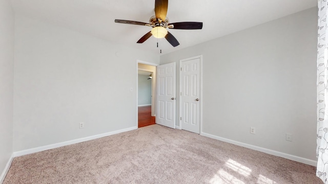 unfurnished bedroom with baseboards, ceiling fan, a closet, and light colored carpet