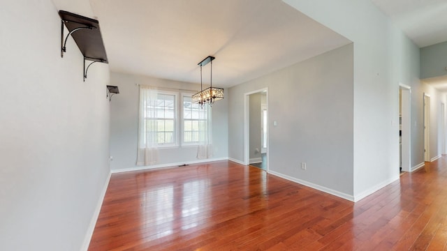 unfurnished dining area with wood finished floors and baseboards