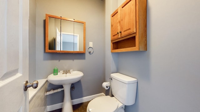 bathroom with baseboards and toilet