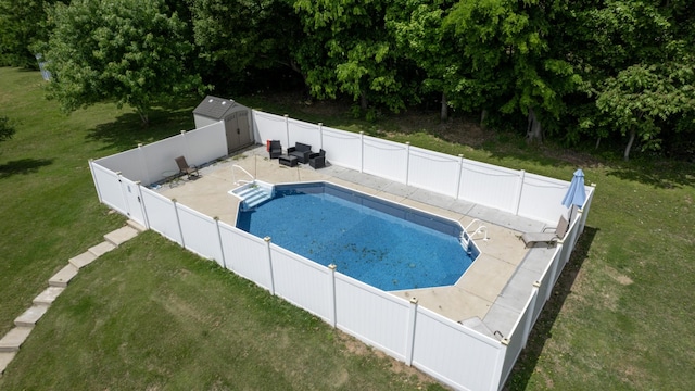 view of swimming pool featuring a fenced in pool, an outbuilding, a yard, a patio, and a storage shed