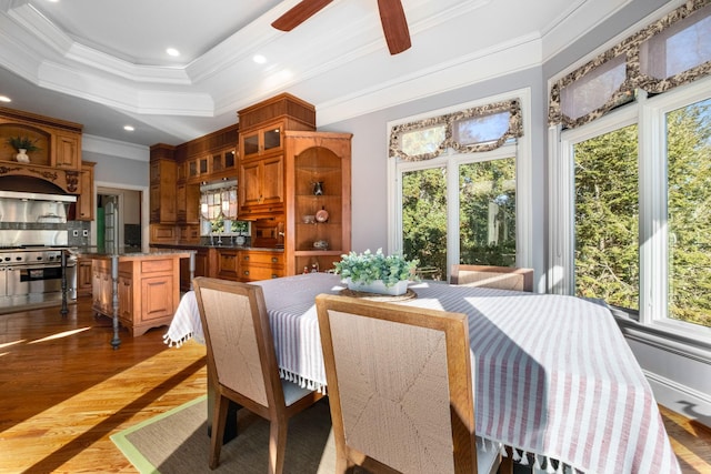 dining area featuring ceiling fan, recessed lighting, dark wood-style floors, a tray ceiling, and crown molding