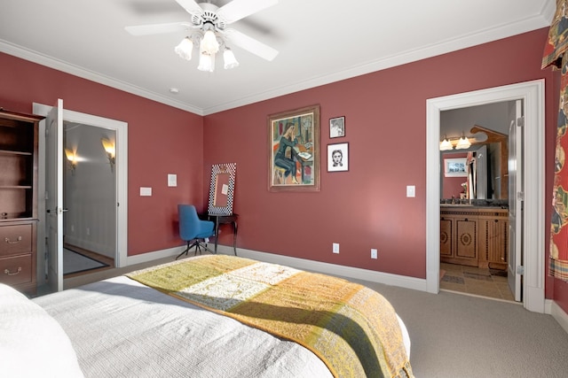 bedroom featuring a ceiling fan, baseboards, carpet, ensuite bath, and crown molding