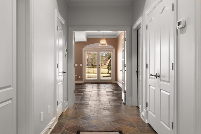 hall with ornamental molding, french doors, baseboards, and stone tile floors