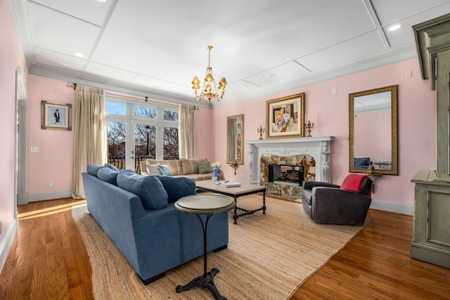 living room with ornamental molding, a premium fireplace, and wood finished floors