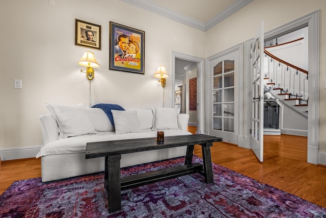 sitting room featuring stairway, baseboards, ornamental molding, and wood finished floors