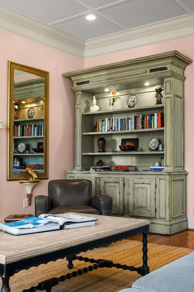 sitting room with light wood finished floors, built in features, and crown molding