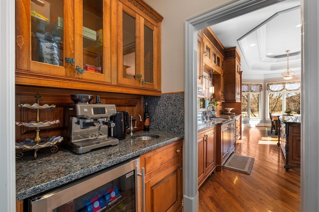 bar with decorative backsplash, dark wood finished floors, wine cooler, a tray ceiling, and a sink