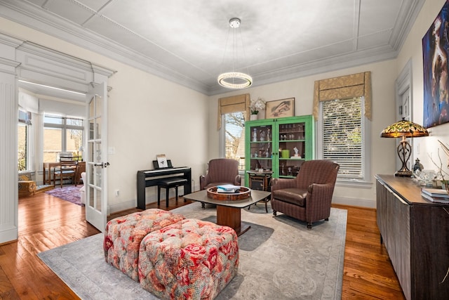 sitting room featuring ornamental molding, french doors, baseboards, and wood finished floors