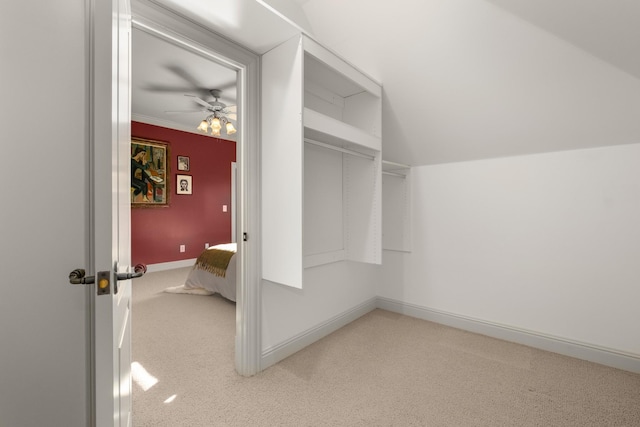 spacious closet featuring a ceiling fan, lofted ceiling, and light colored carpet