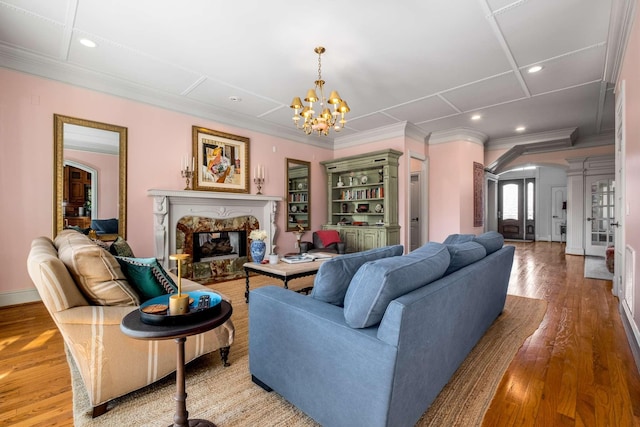 living area with light wood-type flooring, decorative columns, ornamental molding, and a high end fireplace