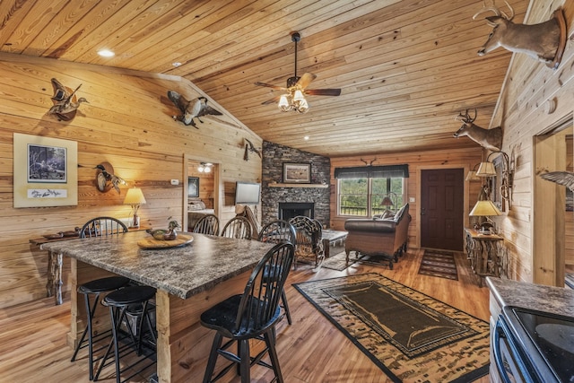 kitchen with open floor plan, wooden ceiling, a fireplace, and light wood finished floors