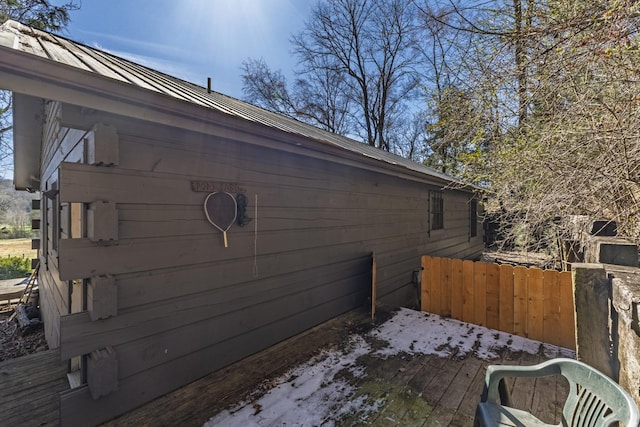 view of side of property with metal roof, a standing seam roof, fence, and a wooden deck