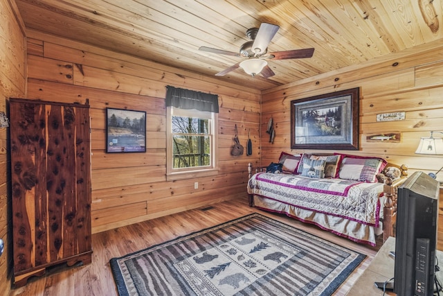 bedroom featuring wood ceiling, wood walls, and wood finished floors