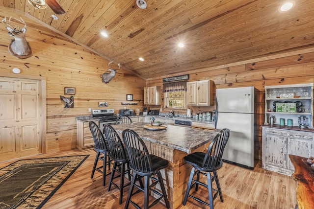 kitchen featuring a center island, a breakfast bar area, lofted ceiling, appliances with stainless steel finishes, and wooden ceiling