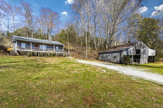 view of yard with driveway and an outdoor structure