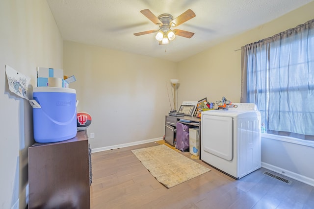 laundry area with laundry area, wood finished floors, visible vents, baseboards, and washer / dryer