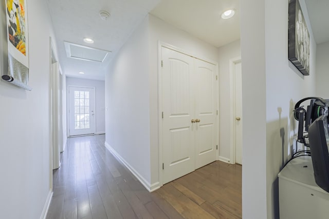 corridor featuring recessed lighting, dark wood finished floors, attic access, and baseboards