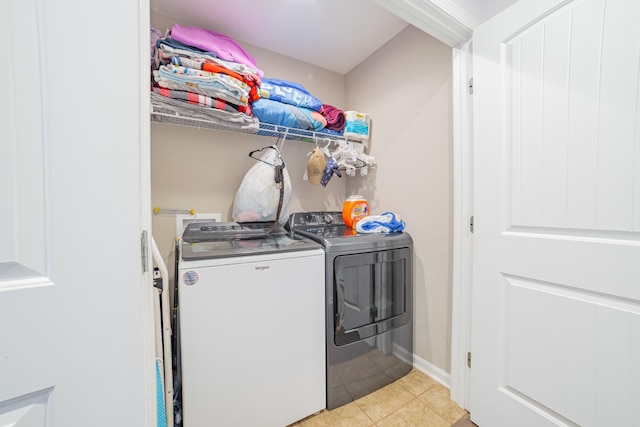 washroom with laundry area, light tile patterned flooring, washing machine and dryer, and baseboards