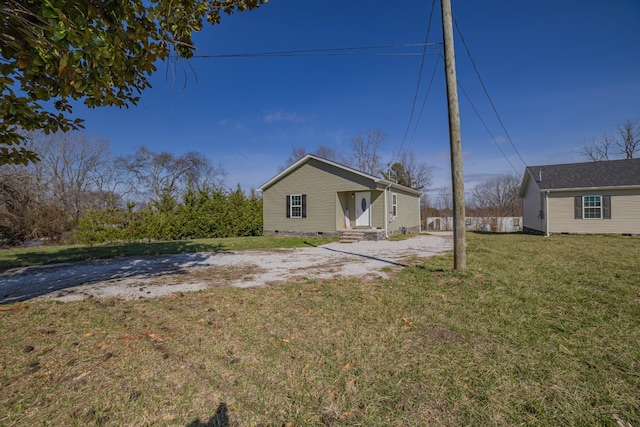 rear view of house with crawl space, driveway, and a lawn