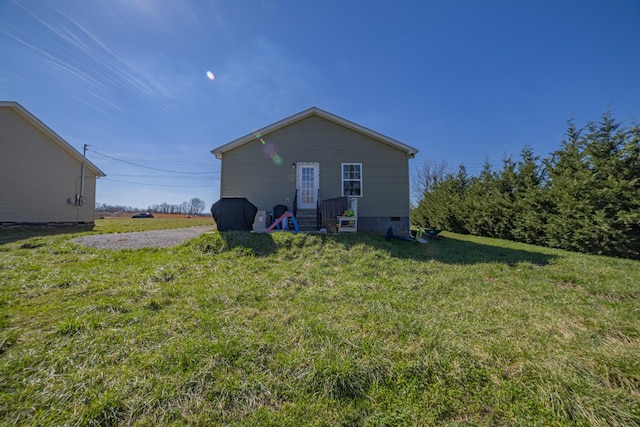 rear view of property featuring crawl space and a yard