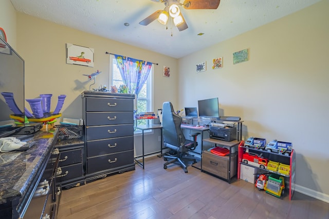 home office with ceiling fan, a textured ceiling, wood finished floors, and baseboards