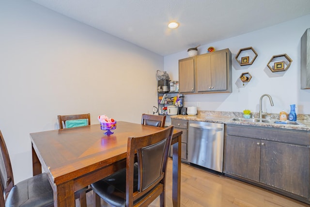 kitchen with a sink, light wood finished floors, and stainless steel dishwasher