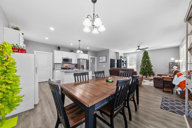 dining area featuring light wood finished floors, a ceiling fan, and recessed lighting