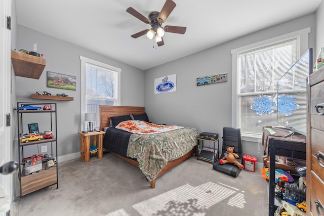 bedroom with ceiling fan, baseboards, and light colored carpet