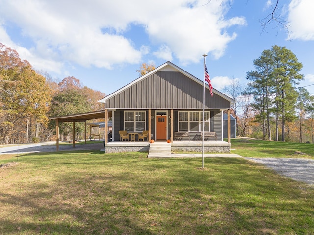 view of front of home featuring covered porch, an attached carport, and a front yard