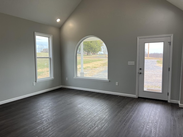 interior space featuring high vaulted ceiling, dark wood finished floors, and baseboards