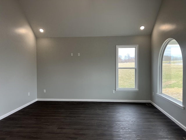 empty room featuring dark wood-style floors, baseboards, vaulted ceiling, and recessed lighting