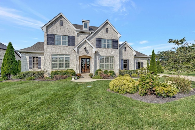 view of front of property featuring a front yard, french doors, and brick siding