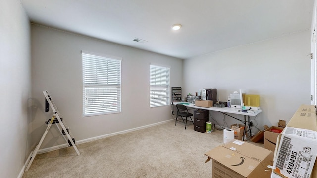 office space featuring light carpet, visible vents, and baseboards