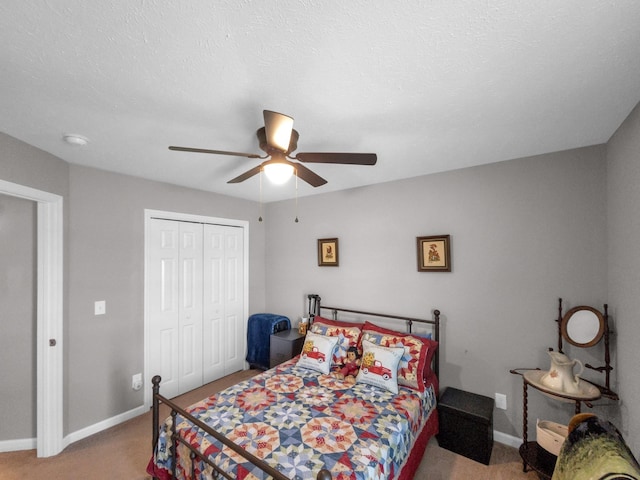 bedroom with ceiling fan, a closet, light colored carpet, and baseboards