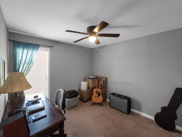 carpeted office featuring a textured ceiling, a ceiling fan, and baseboards