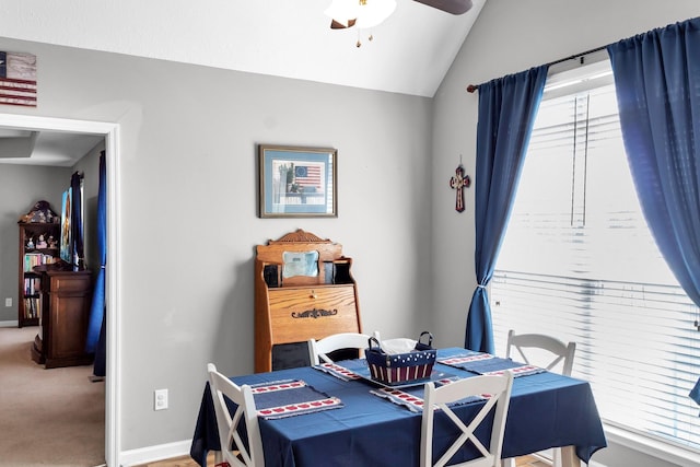 dining space featuring vaulted ceiling, ceiling fan, carpet, and baseboards