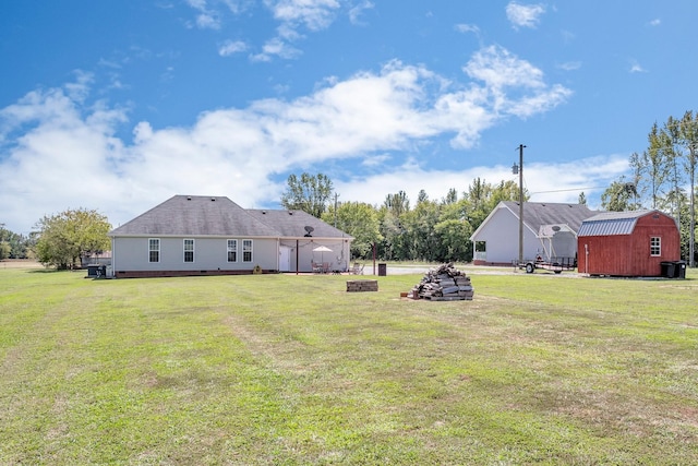 view of yard with a storage shed, an outdoor fire pit, and an outdoor structure