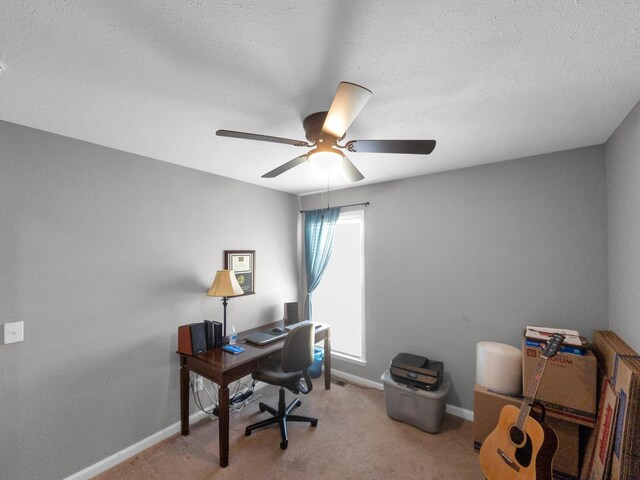 home office featuring carpet floors, a ceiling fan, baseboards, and a textured ceiling