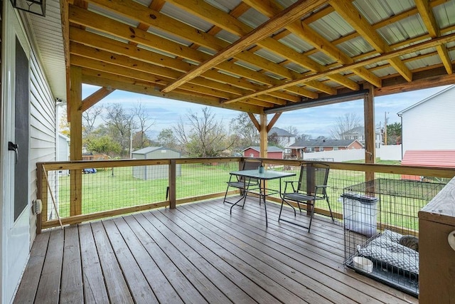 deck with outdoor dining area and a lawn