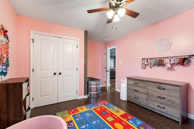 bedroom with dark wood-style floors, a closet, ceiling fan, and baseboards