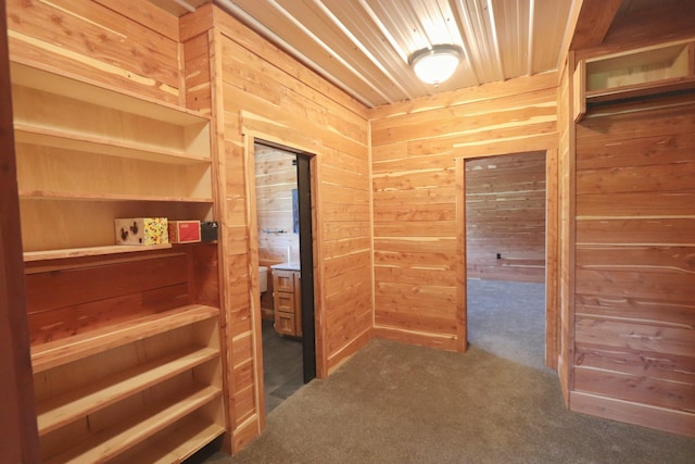 hall featuring wooden ceiling, wooden walls, and dark colored carpet