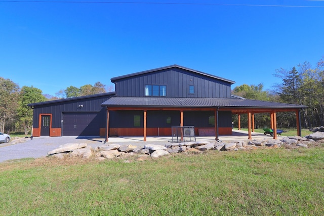 view of front facade with an attached garage, metal roof, a front yard, and driveway