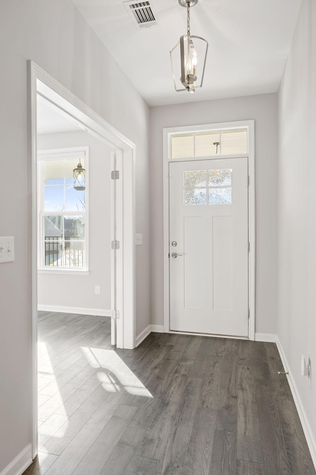 entryway featuring dark wood-type flooring, plenty of natural light, baseboards, and visible vents