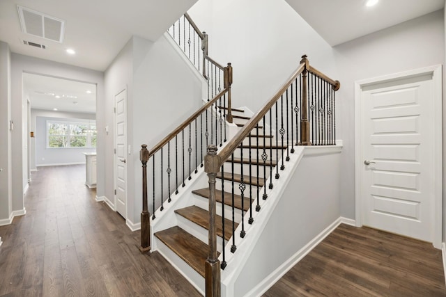 stairs featuring visible vents, baseboards, and wood finished floors