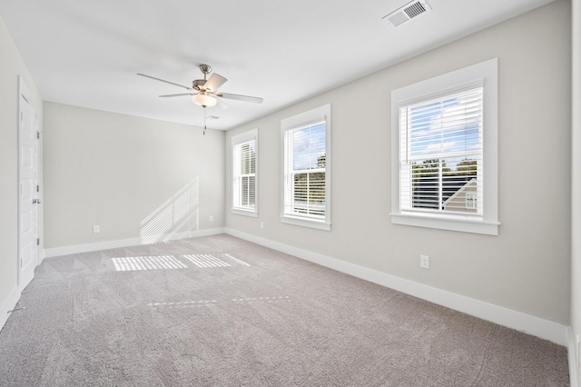 unfurnished room featuring visible vents, ceiling fan, light carpet, and baseboards