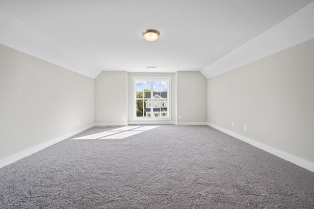 bonus room with carpet floors, visible vents, baseboards, and lofted ceiling