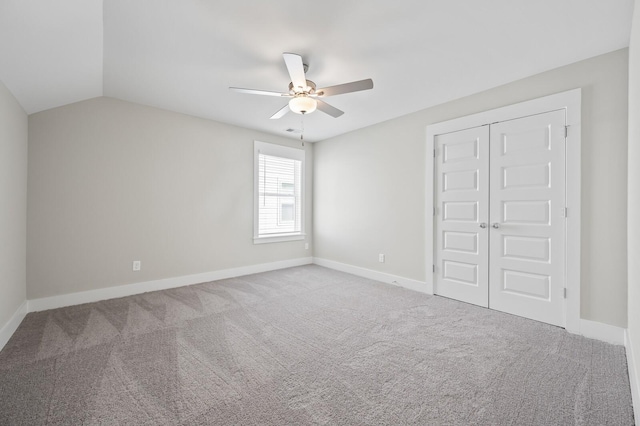 unfurnished bedroom with baseboards, a ceiling fan, lofted ceiling, carpet floors, and a closet