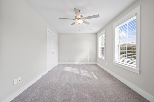 spare room featuring carpet flooring, a ceiling fan, and baseboards