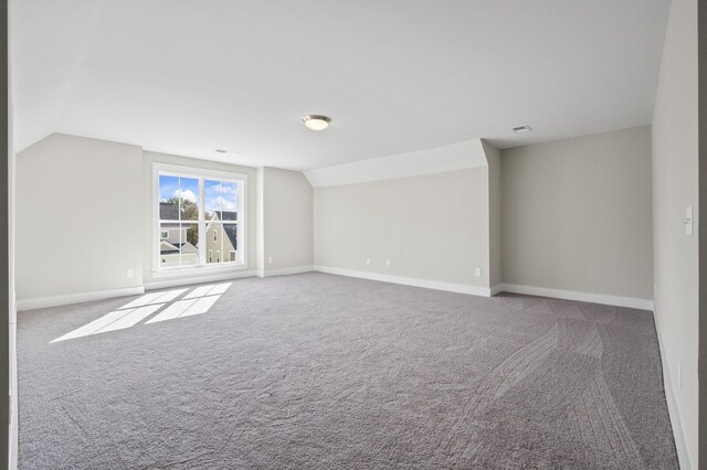 bonus room featuring vaulted ceiling, carpet flooring, and baseboards